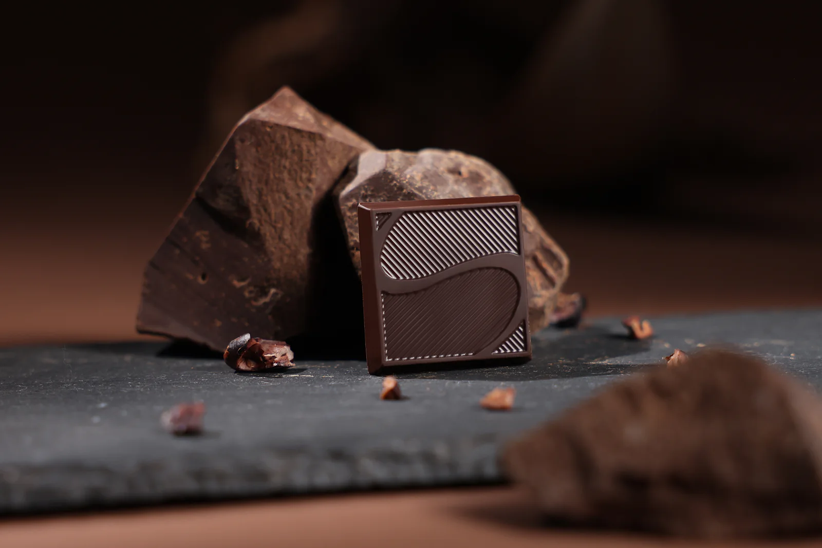 Chocolate squares arranged on a dark stone surface
